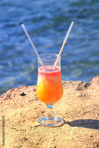 fresh juice orange and papaya on the beach of the sea