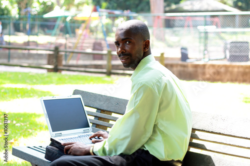 african businessman working outdoors with a laptop