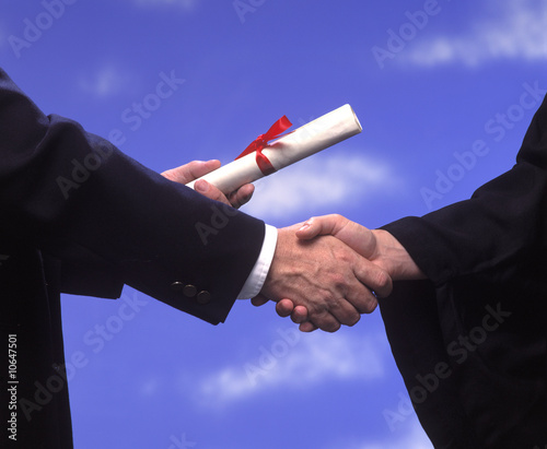 presentation of a diploma and a handshake at graduation