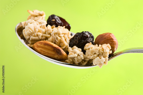 spoon with cereal, nuts and raisin