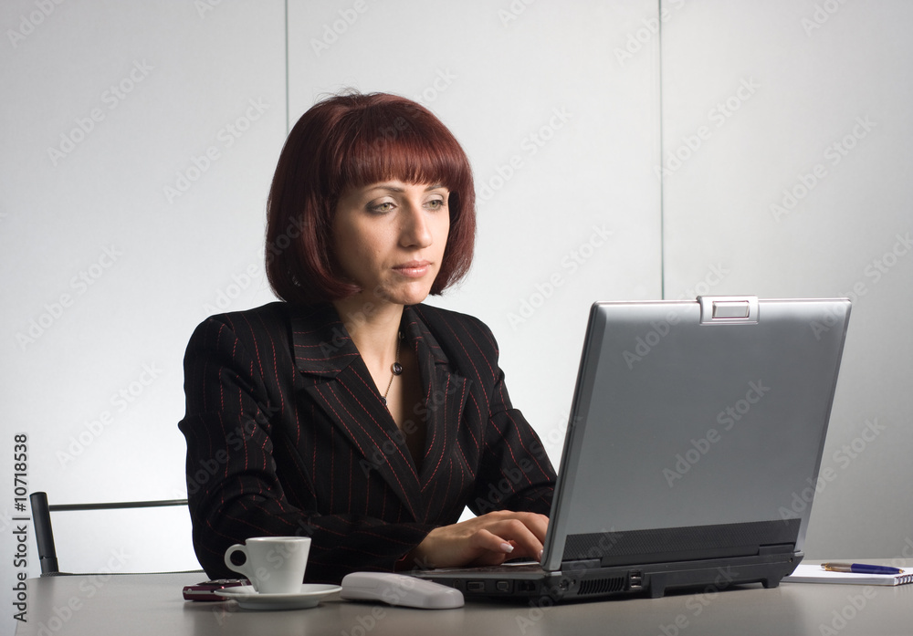 Beautiful businesswomen behind a desktop and a laptop Beautiful businesswomen behind a desktop and a laptop
