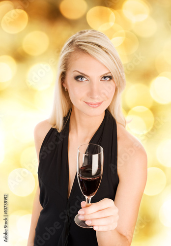 Beautiful young woman with a glass of wine over abstract blurred