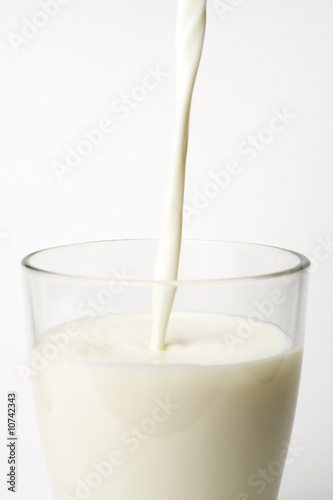 pouring fresh glass of milk isolated