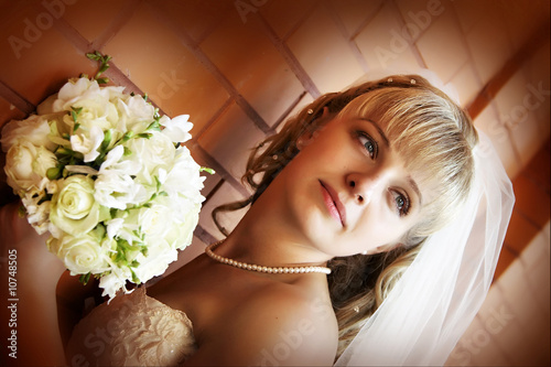 Beautiful bride over brick wall