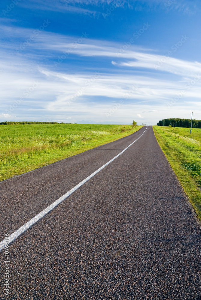 Empty rural road and cloudy sky