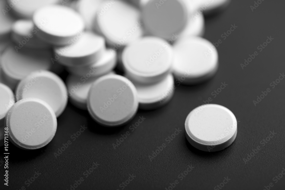 white pills over black background white pills over black background