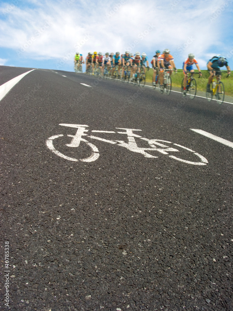 Obraz premium Roadside bicycle lane mark and cyclists racing