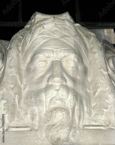 Visage de vieil homme sculpté en pierre blanche.