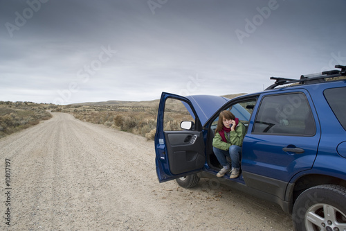 Teenage girl with a broken car