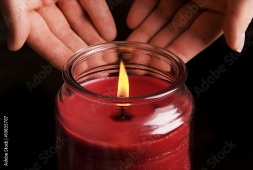 Warm candle. Low key image.