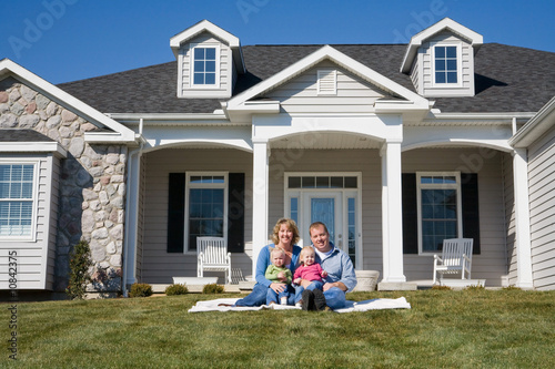 Happy Family in Front of Their Home