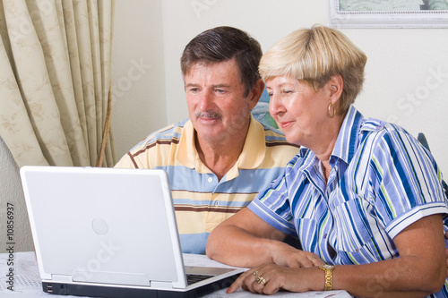 happy senior couple using laptop computer home