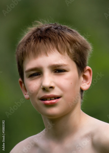 Portrait of the boy on a background of green trees