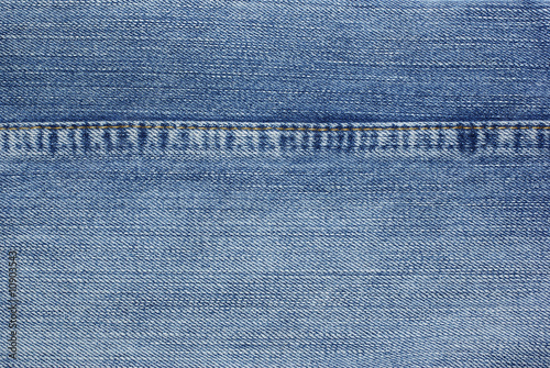 Blue jeans with yellow stitches background.