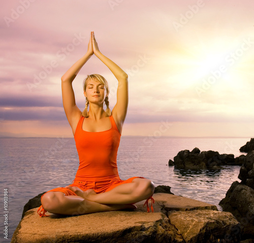 Beautiful young woman doing yoga exercise outdoors