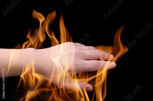Man's hand burning in a flame