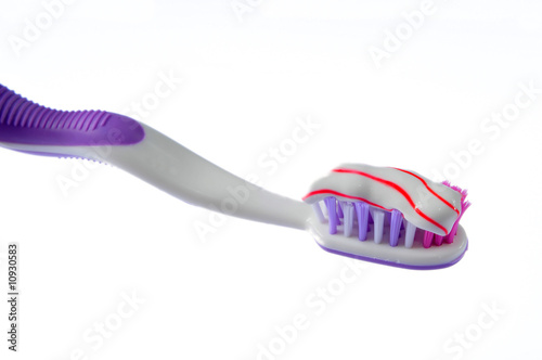 toothbrush covered by toothpaste isolated on white