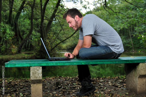 young businessman working on laptop outdoor