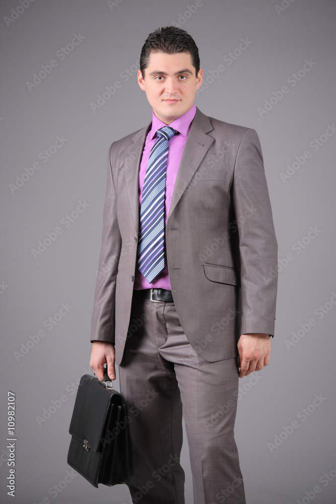 Businessman with a briefcase against grey background Businessman with a briefcase against grey background