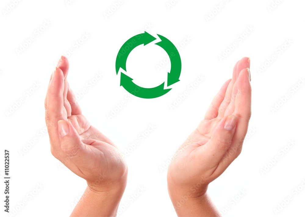 . recycling symbol between two human hands . recycling symbol between two human hands