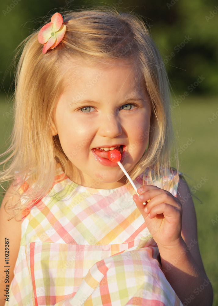 happy little girl licking a lollipop happy little girl licking a lollipop