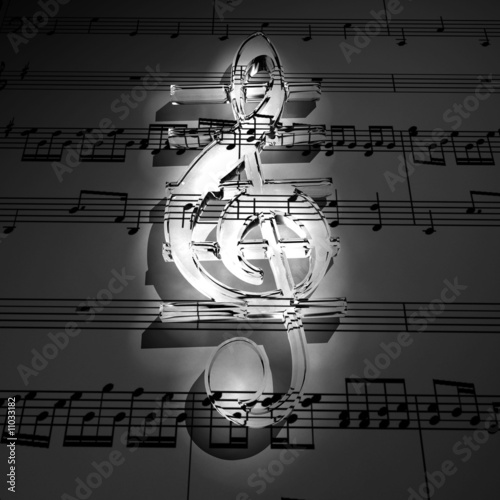 Transparent 3d treble clef with shadow on dark staff background