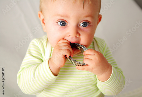 Quadro em tela Bebe tiens un truc dans ses mains et mange