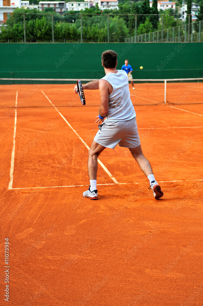 Man plays tennis outdoors