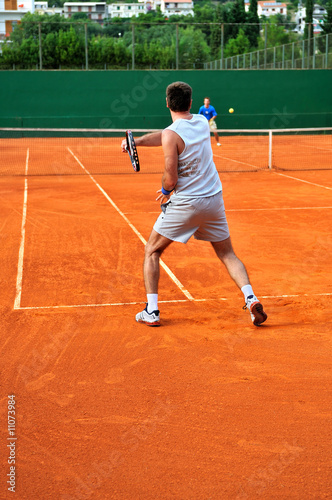 Man plays tennis outdoors © .shock