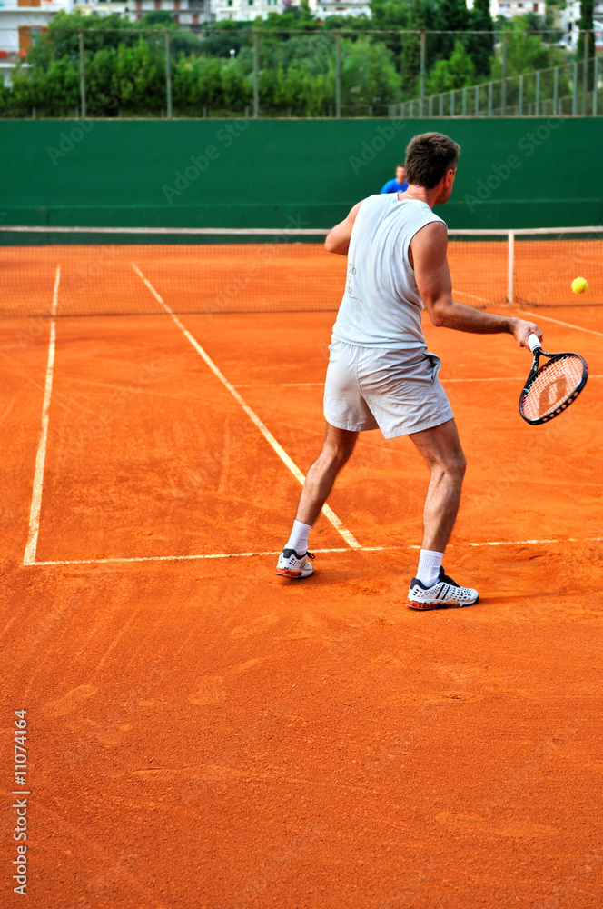 Man plays tennis outdoors