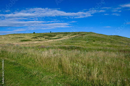 Green hill with blue sky