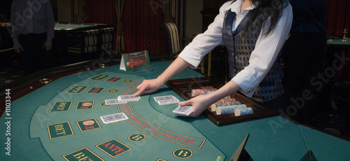 croupier handling cards at poker table photo