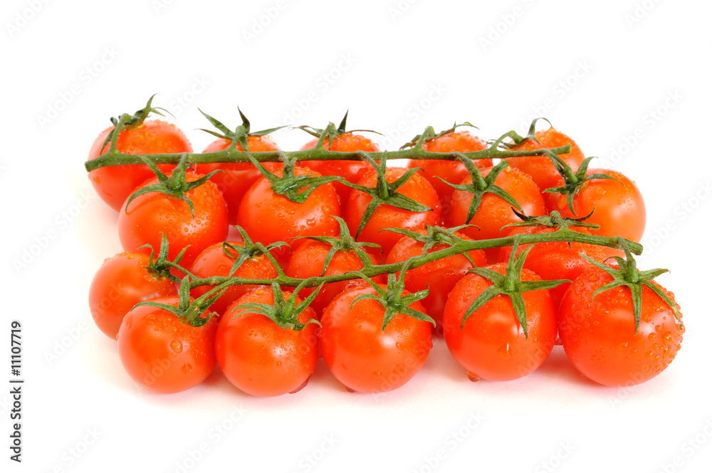 Bunch of cherry tomatoes with water drops isolated on white