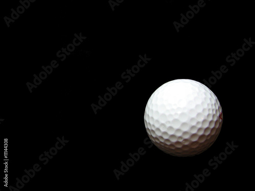 Isolated golf ball on black
