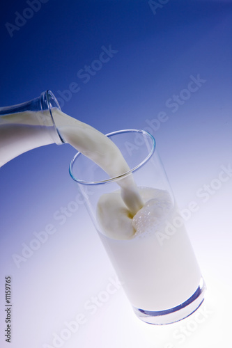 pouring creamy fresh milk in a transparent glass