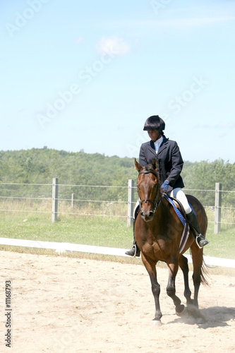 black teenage girl riding her horse in the show ring
