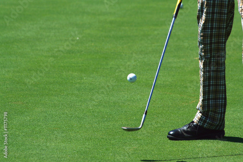 Golfer juggling a golf ball with retro pants