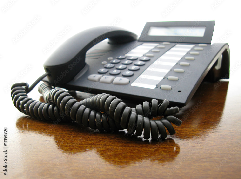 Telephone black on brown office desk Telephone black on brown office desk
