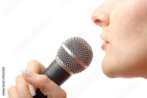 Caucasian girl singing with microphone.