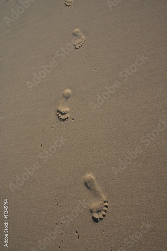 Trois empreintes de pied dans le sable photo