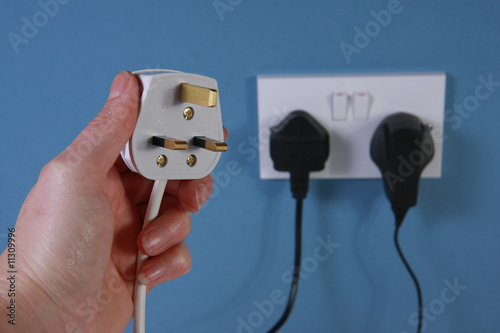 Left hand holding a plug