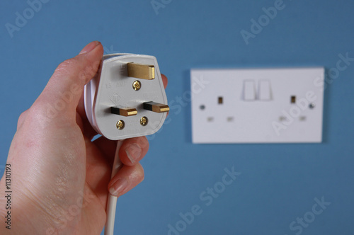 Left hand holding a plug