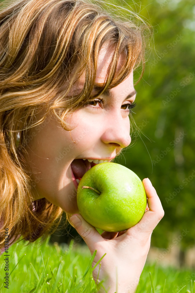 pretty woman eating green apple on the summer glade pretty woman eating green apple on the summer glade