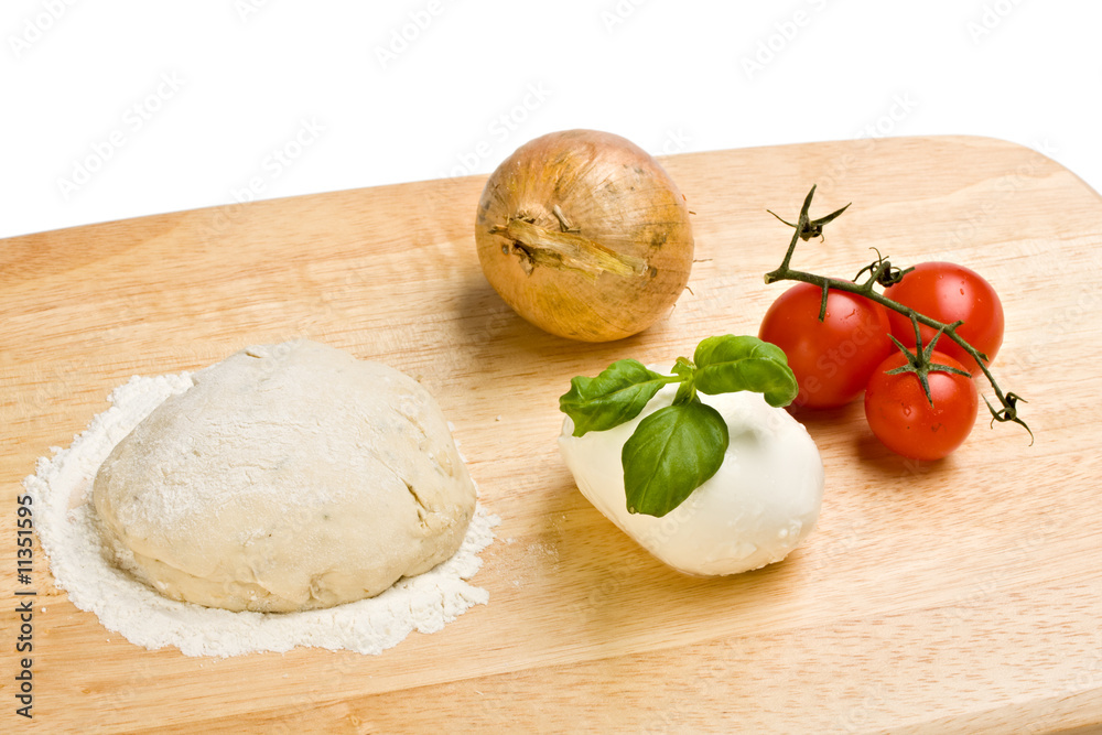 Hefeteig, Käse, Tomaten und Zwiebeln auf einem Holzbrett Hefeteig, Käse, Tomaten und Zwiebeln auf einem Holzbrett