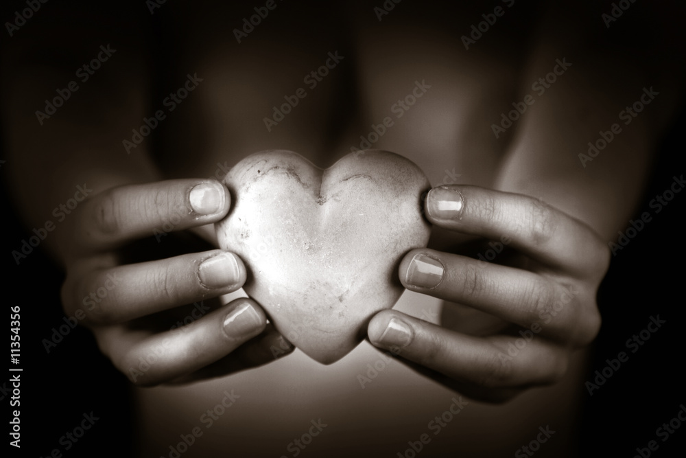 Fototapeta premium Woman holding marmoreal heart in front of her - goth look