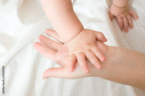 Hands of small baby and mother