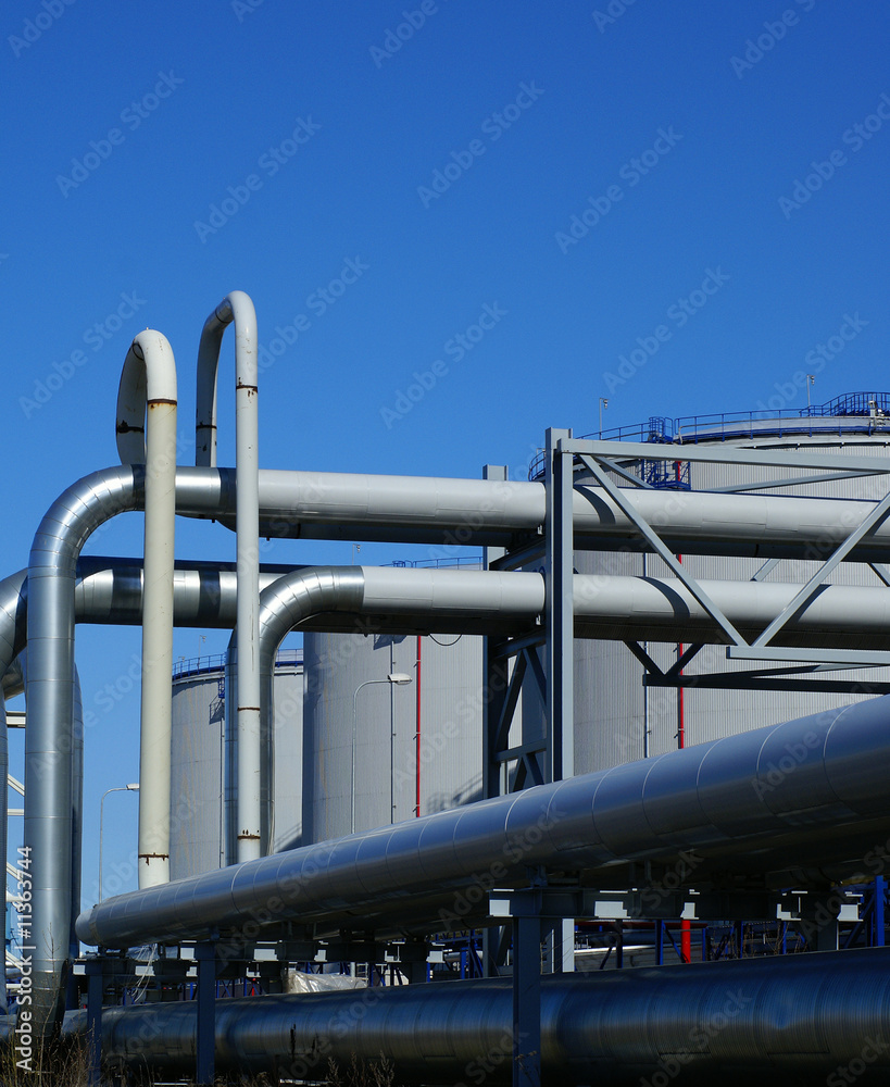 industrial pipelines and storage tanks against blue sky industrial pipelines and storage tanks against blue sky