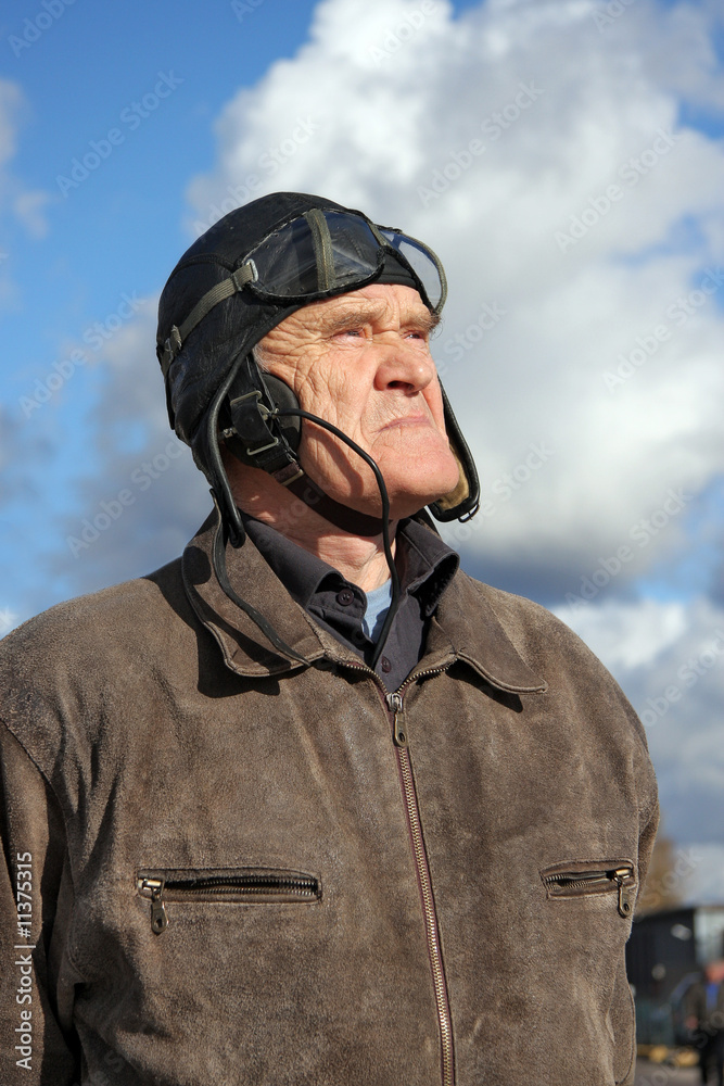 old pilot in old uniform looking upstairs to the sky