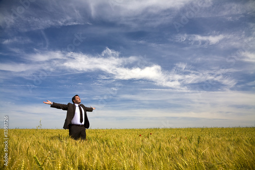 businessman with his arms wide open in rural field