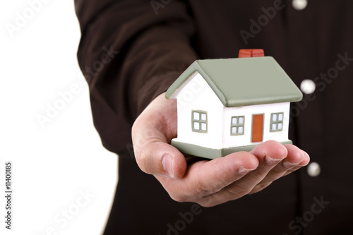 man holding a small house in his hand